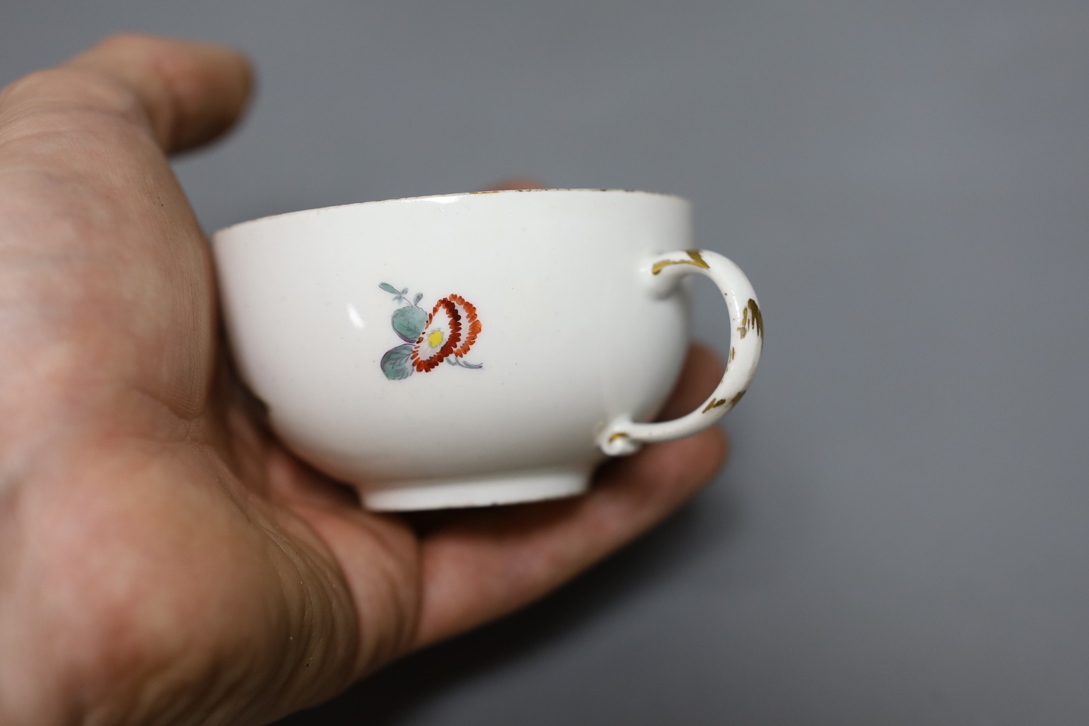 A Meissen teacup and saucer painted with a landscape with children in robes with recumbent sheep, crossed swords mark and dot in underglaze-blue, impressed numerals, saucer 13.5 cms diameter